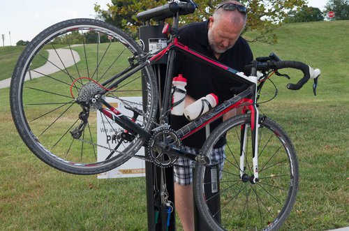 Mike Wise, director of recreation services, uses a new bicycle repair station to air a tire. 